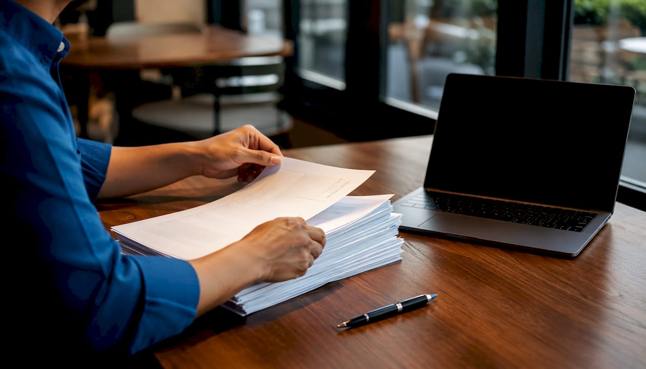 Hands holding FDA compliance documents over desk